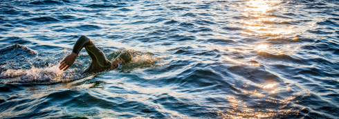 persoon zwemt in natuurwater
