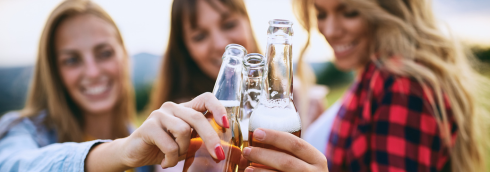 drie dames die proosten met bierflesjes